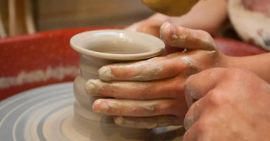 Child's hands at a potter's wheel